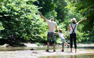 Father and mother and daughter play in the river